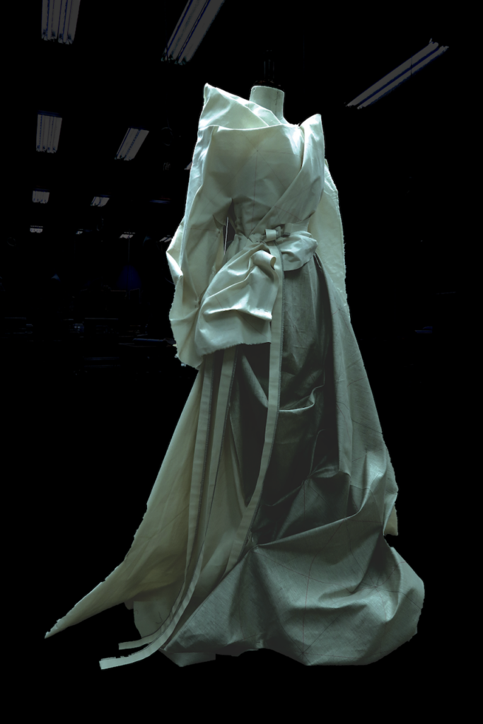 Draped toile, ghostlike dress in darkened studio